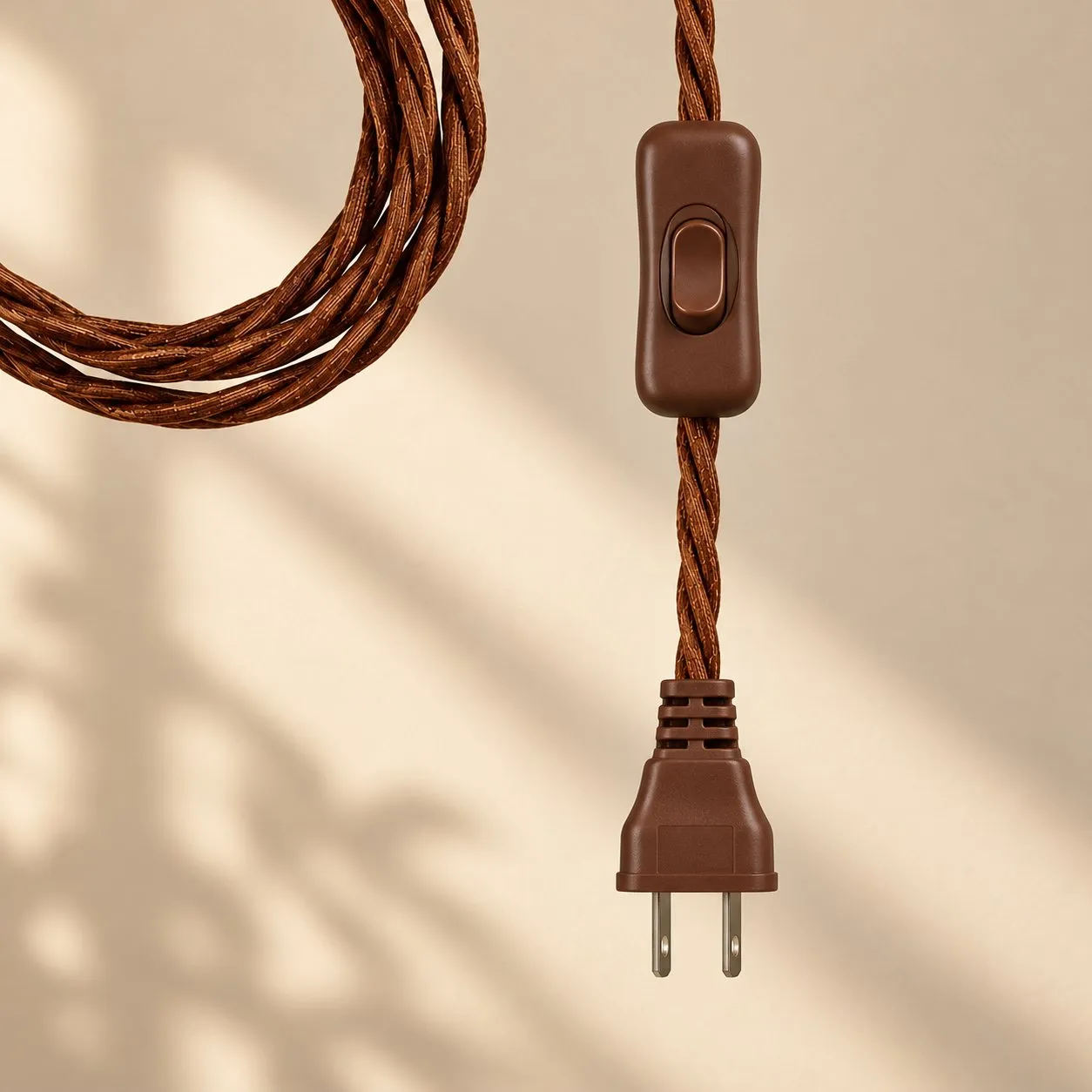 Enchufe US con dos patillas planas paralelas, en un cable textil marrón.