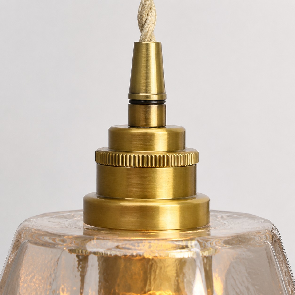 Close view of the antique brass holder above the faceted shade