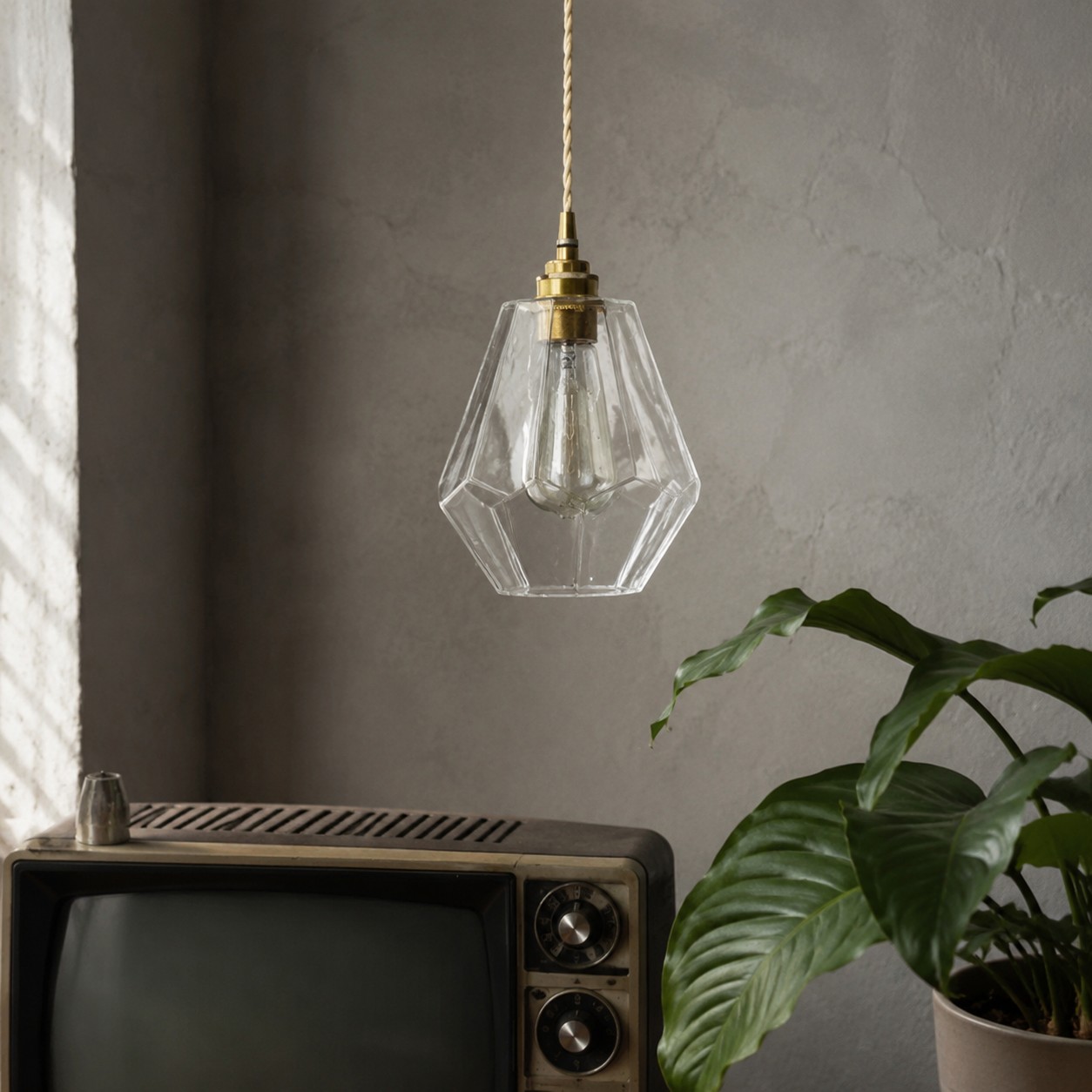 Full view of the clear faceted glass pendant in a quiet interior