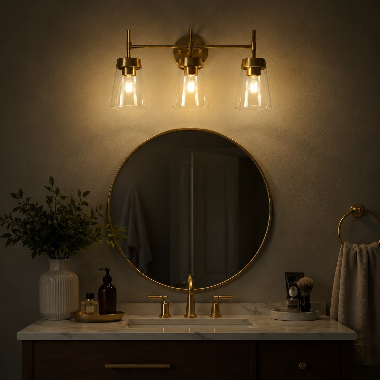 Clear cone glass shades glowing above a bathroom mirror