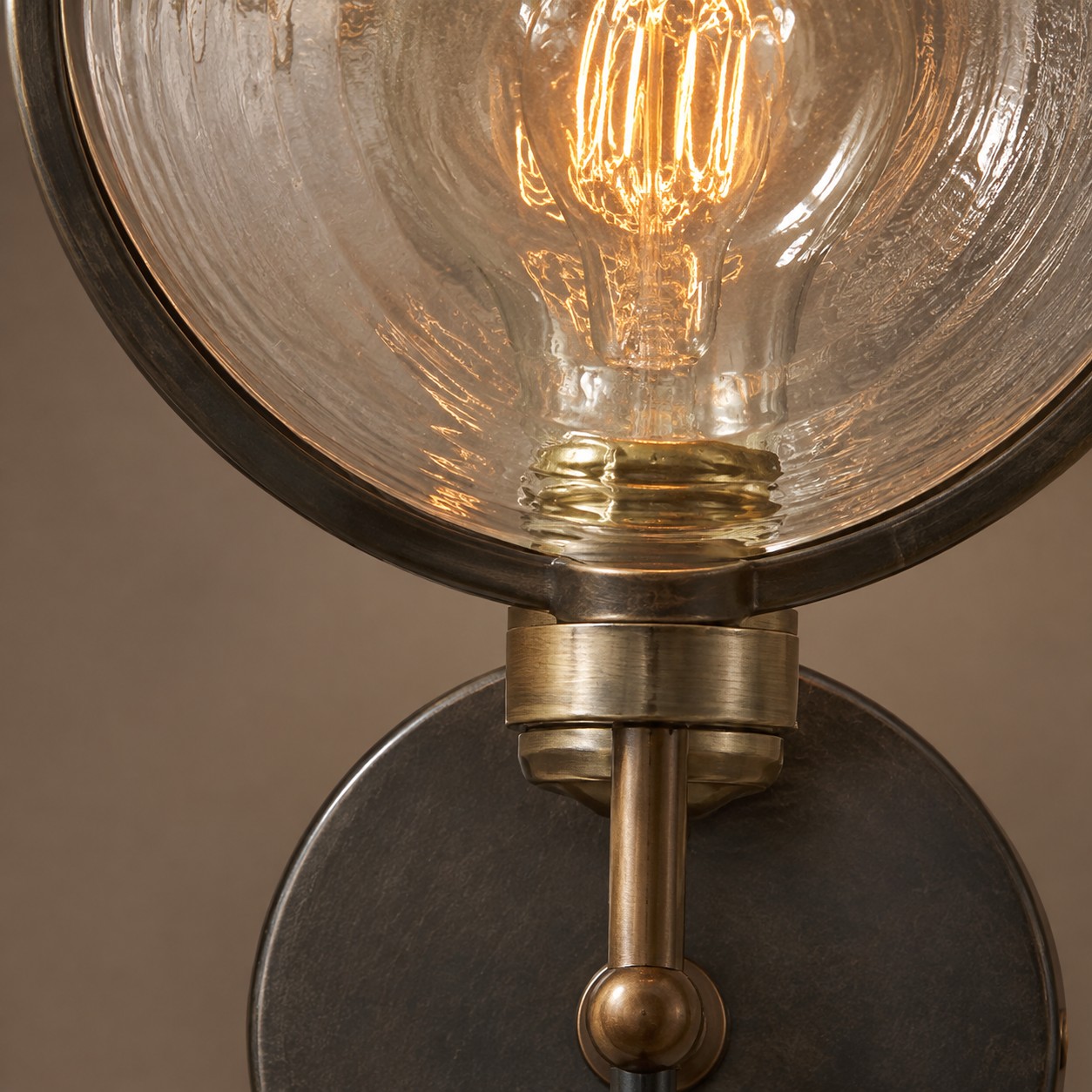 Close-up of the E27 socket, warm filament bulb, and glass disc rim