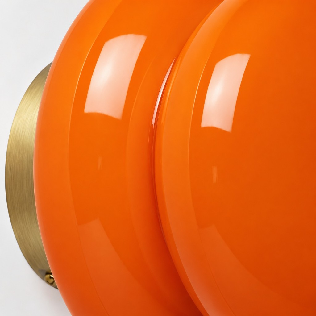 Orange opal glass meeting a brushed brass disc with visible screw