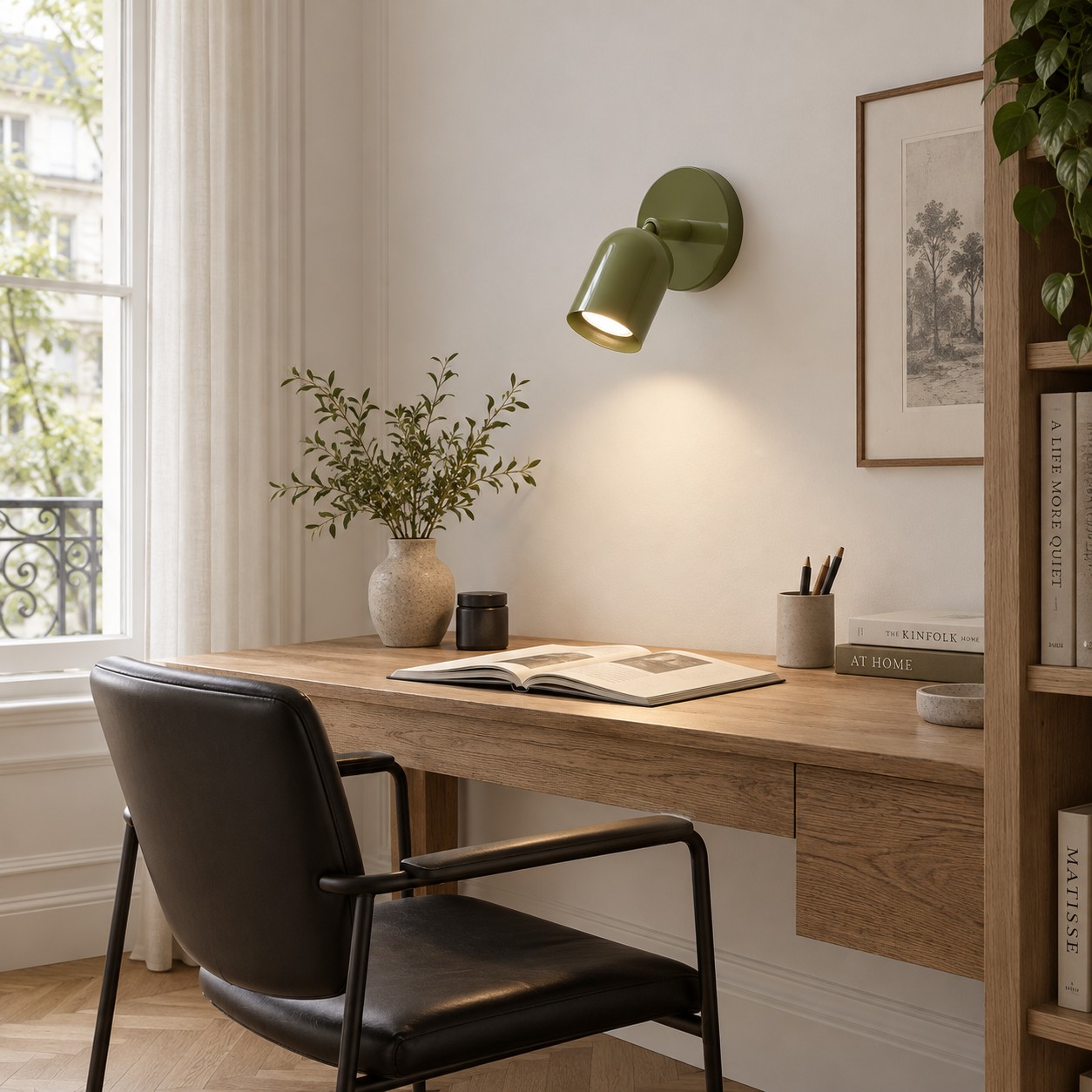 Groene, bedrade wandlamp boven een bureau