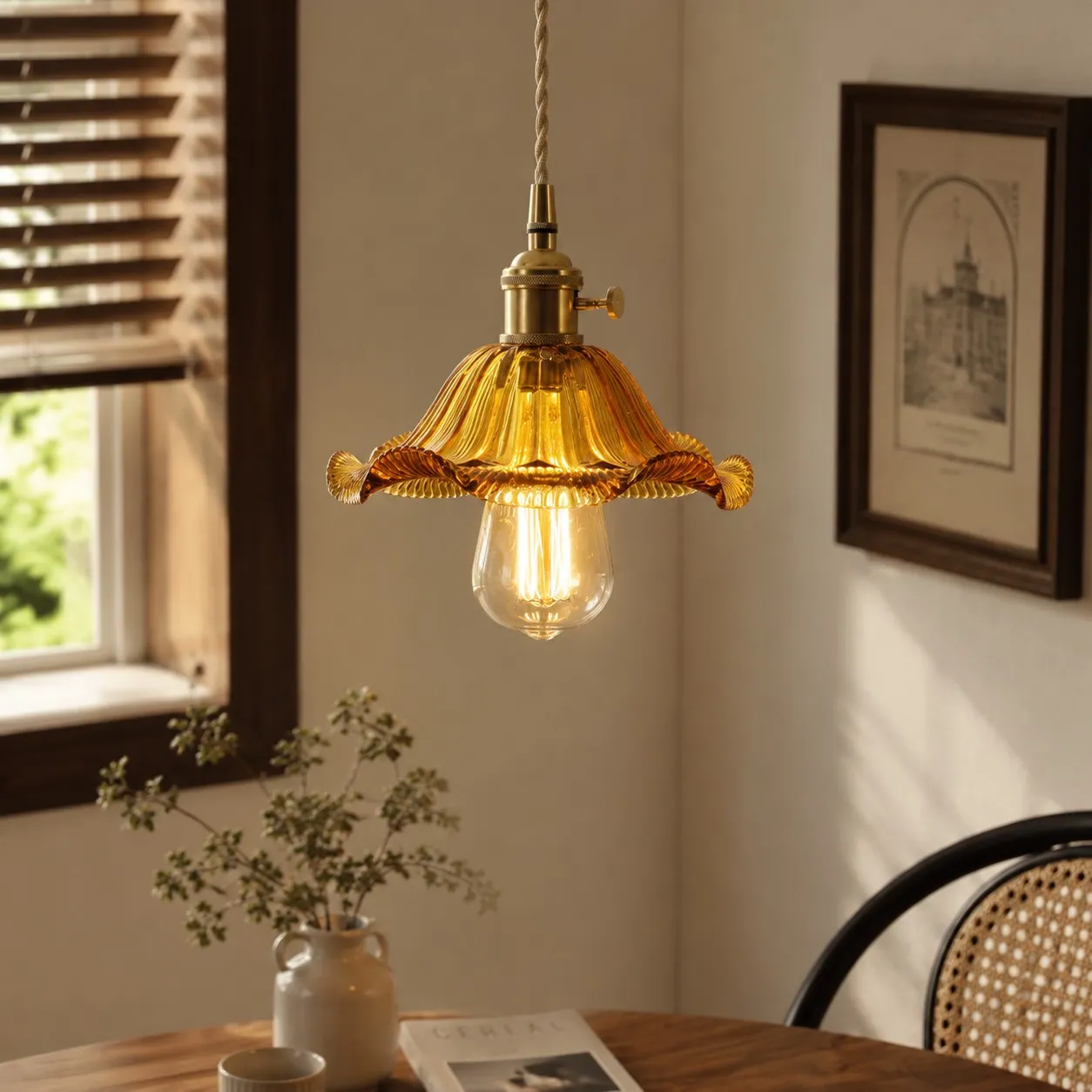 Style L amber glass pendant glowing beside a rattan chair
