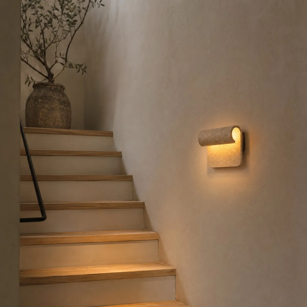 Travertine wall sconce beside a staircase