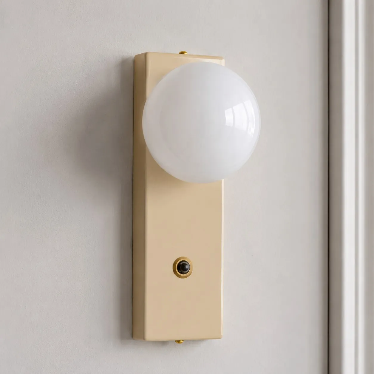 Cream wall sconce with opal glass globe and toggle switch