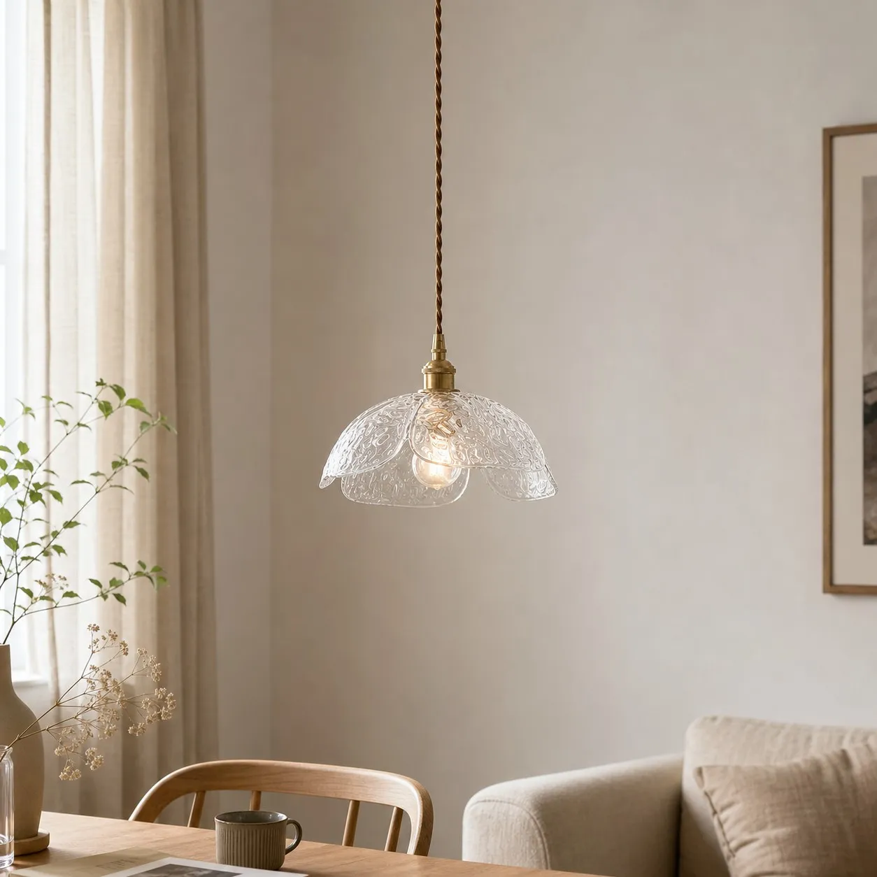 Clear glass flower pendant above a light dining nook