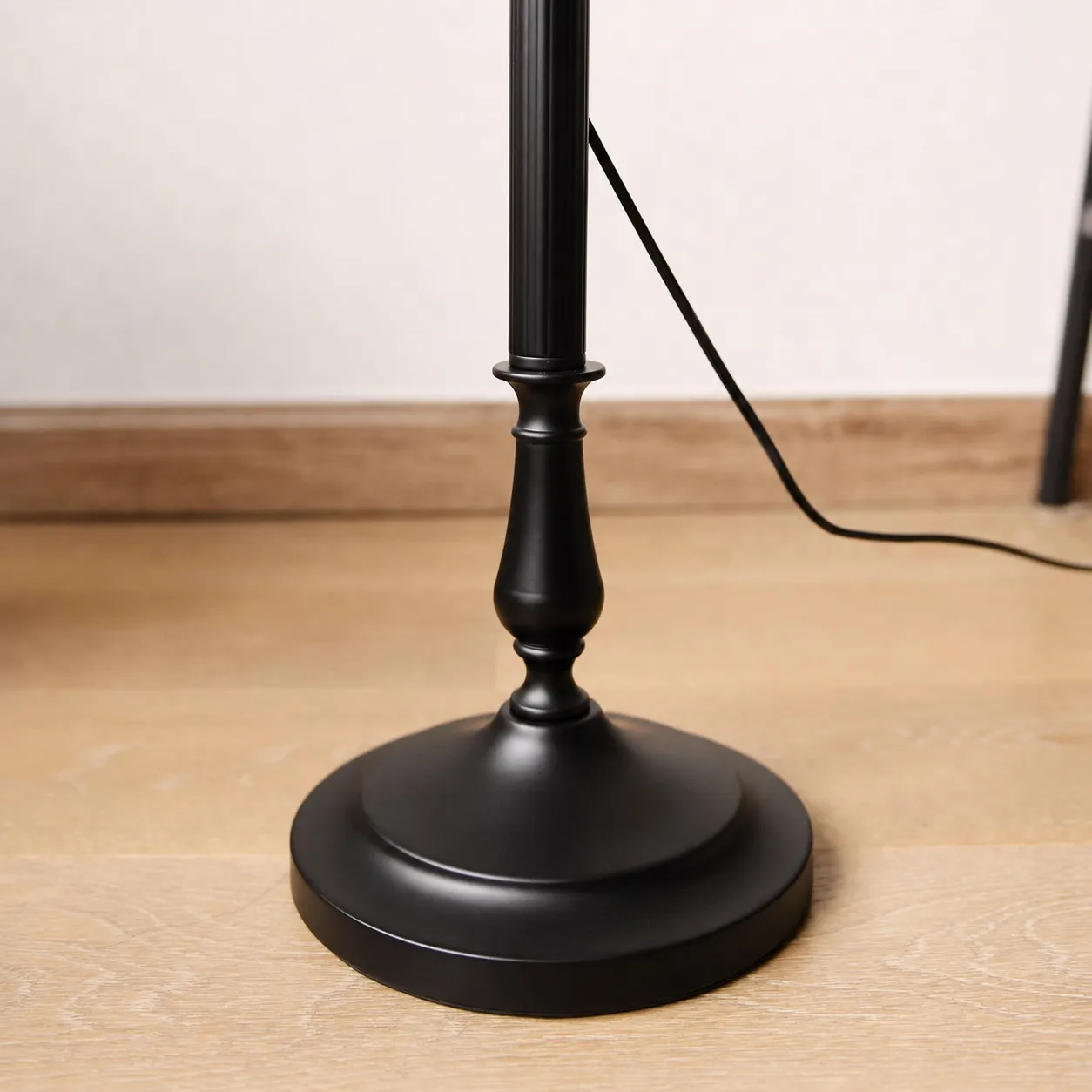 Black metal floor lamp base and foot switch cord detail