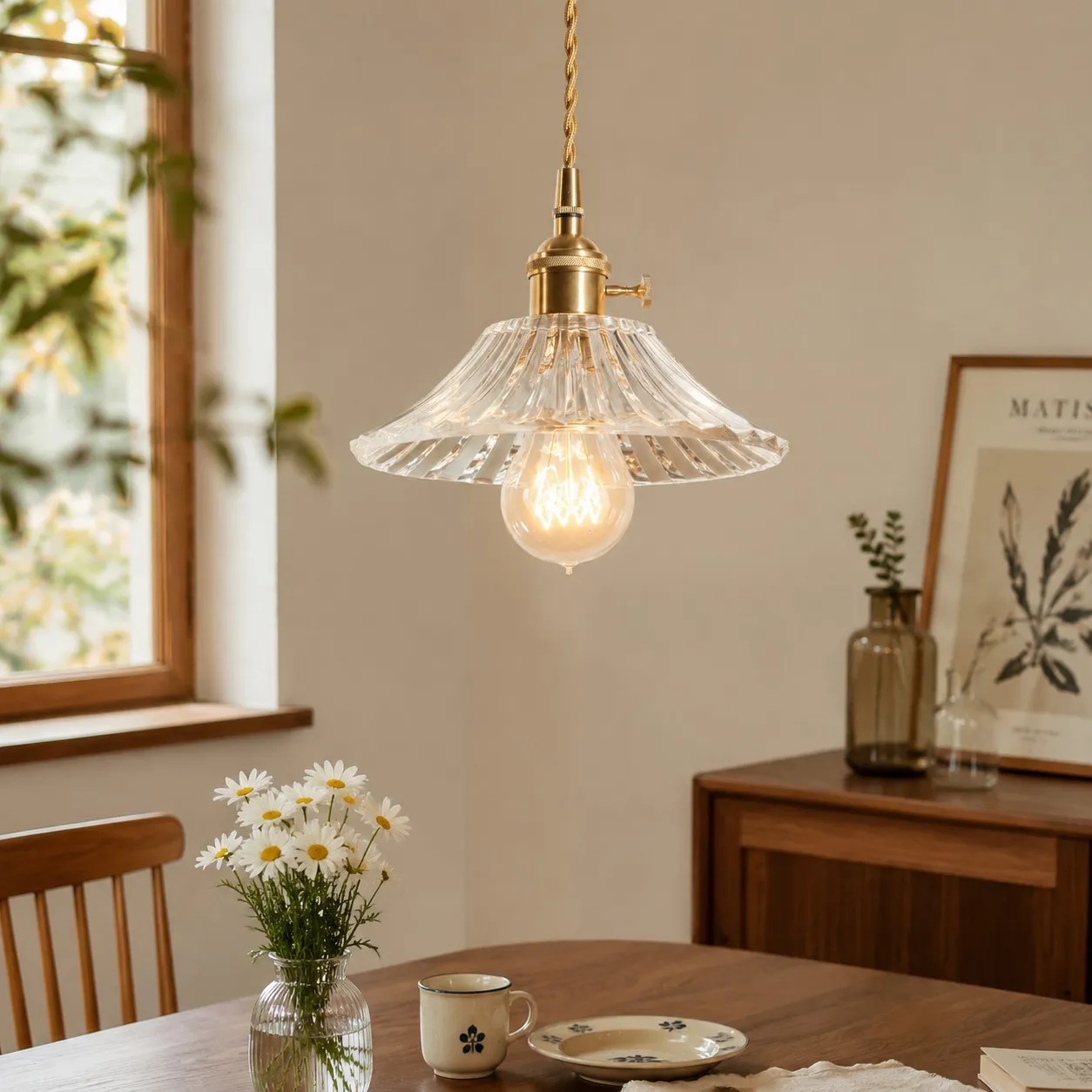 Style I flared clear glass pendant above a dining table