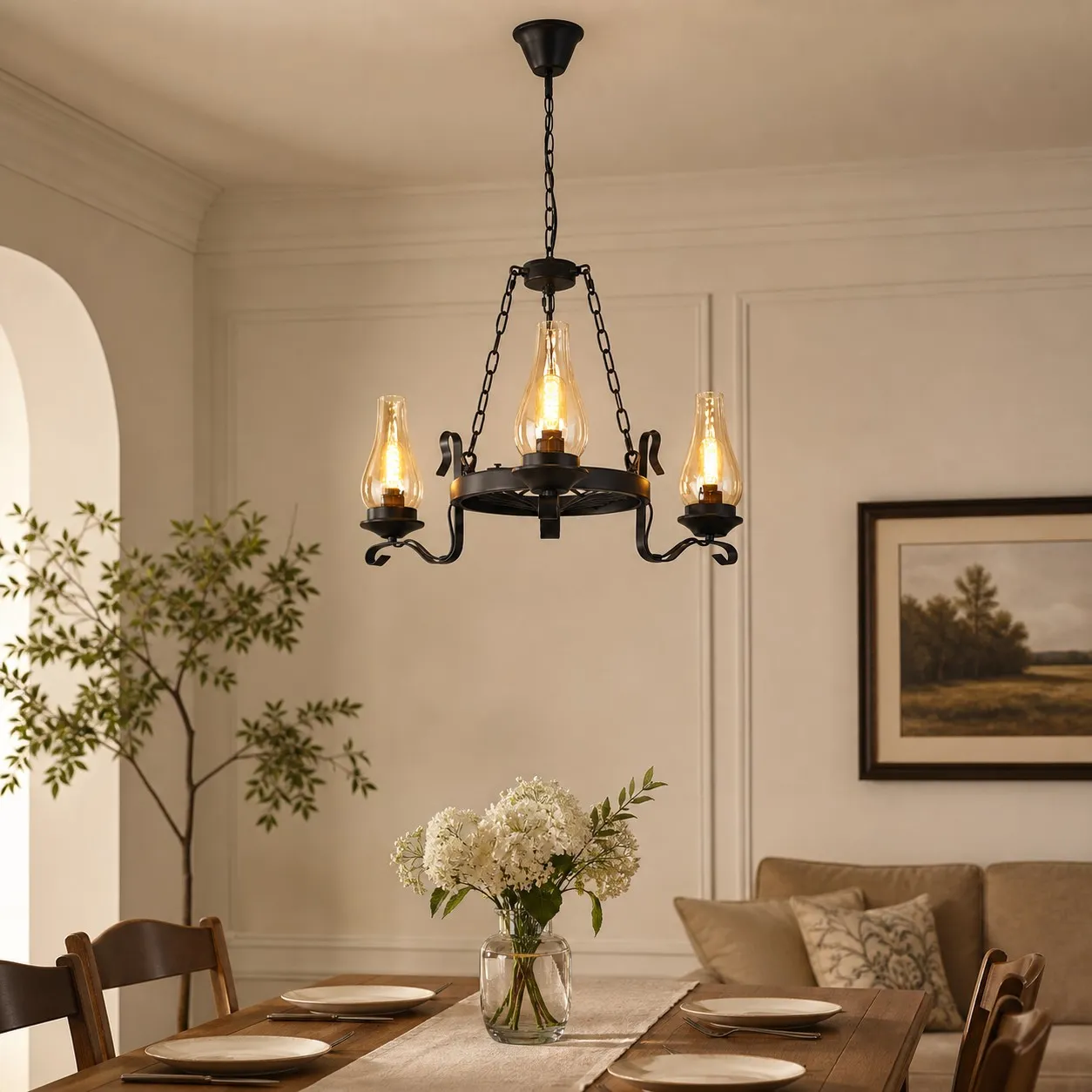 Three-light hurricane glass chandelier above a warm dining table