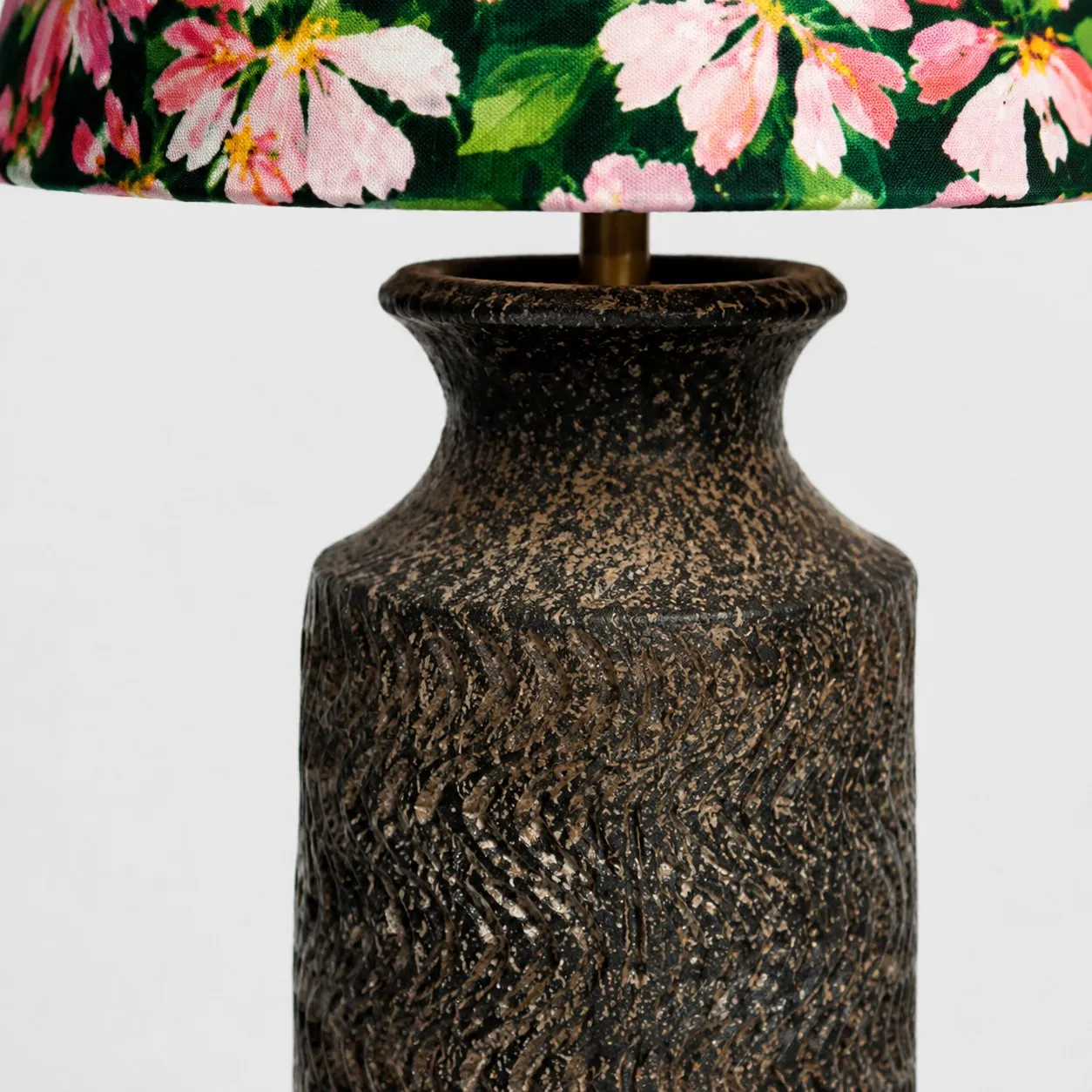 Close-up of brass stem connection between floral shade and ceramic base