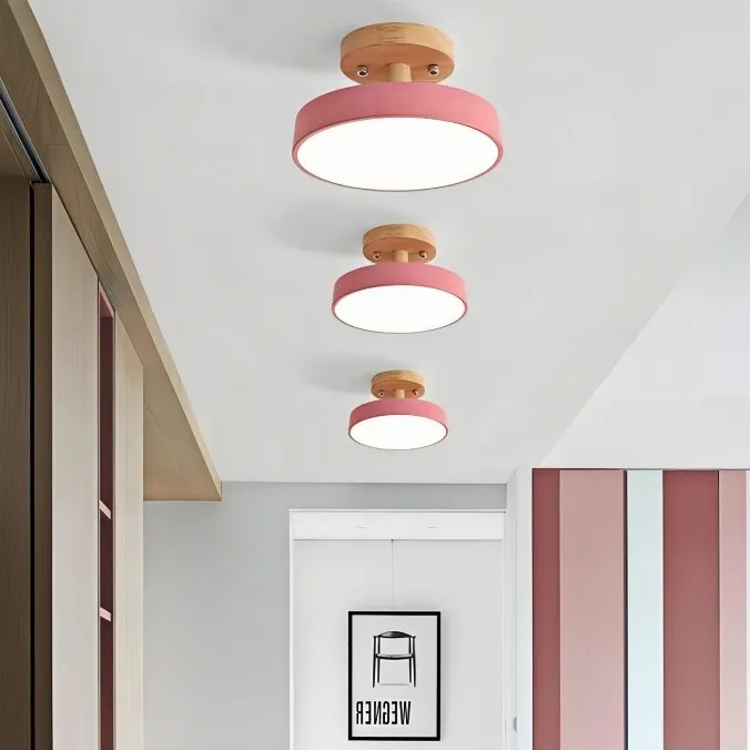 Tre lampade da soffitto rosa in un corridoio