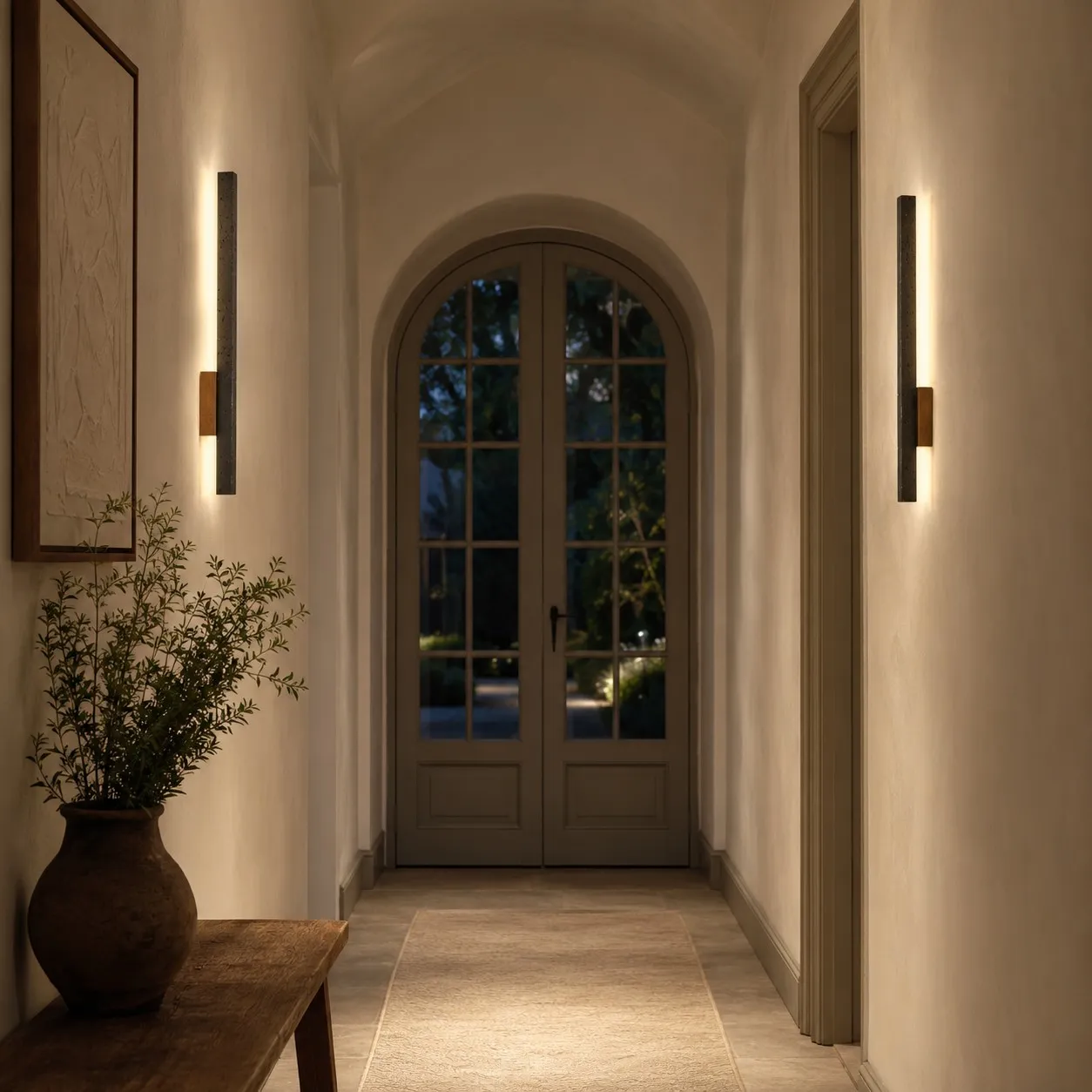 Paired black linear wall lights in arched hallway