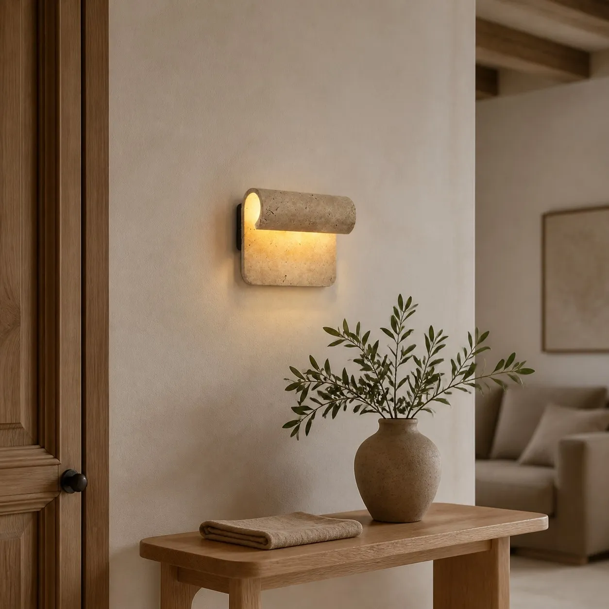 Travertine wall sconce in an entryway with olive branches
