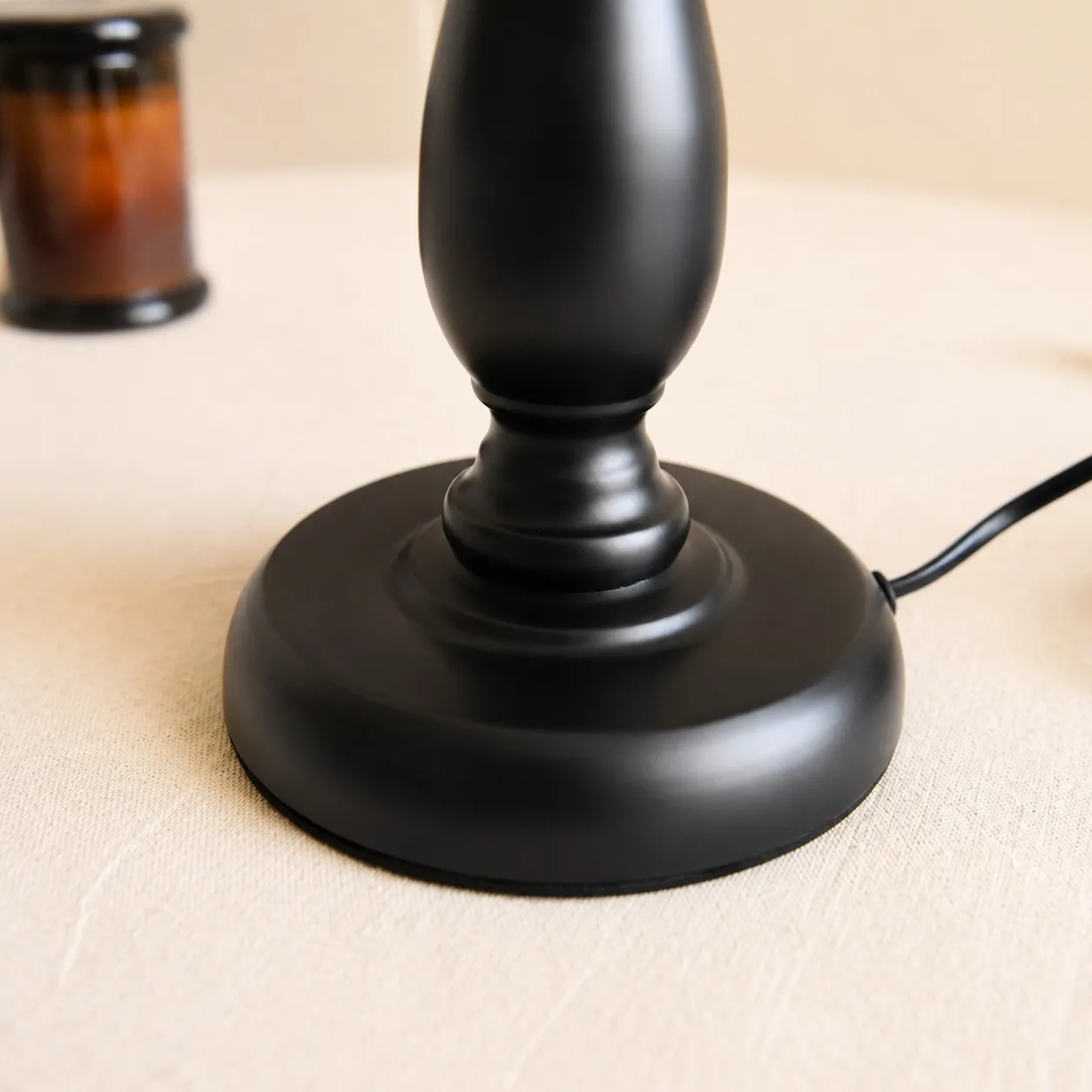 Close view of black iron lamp base and cord