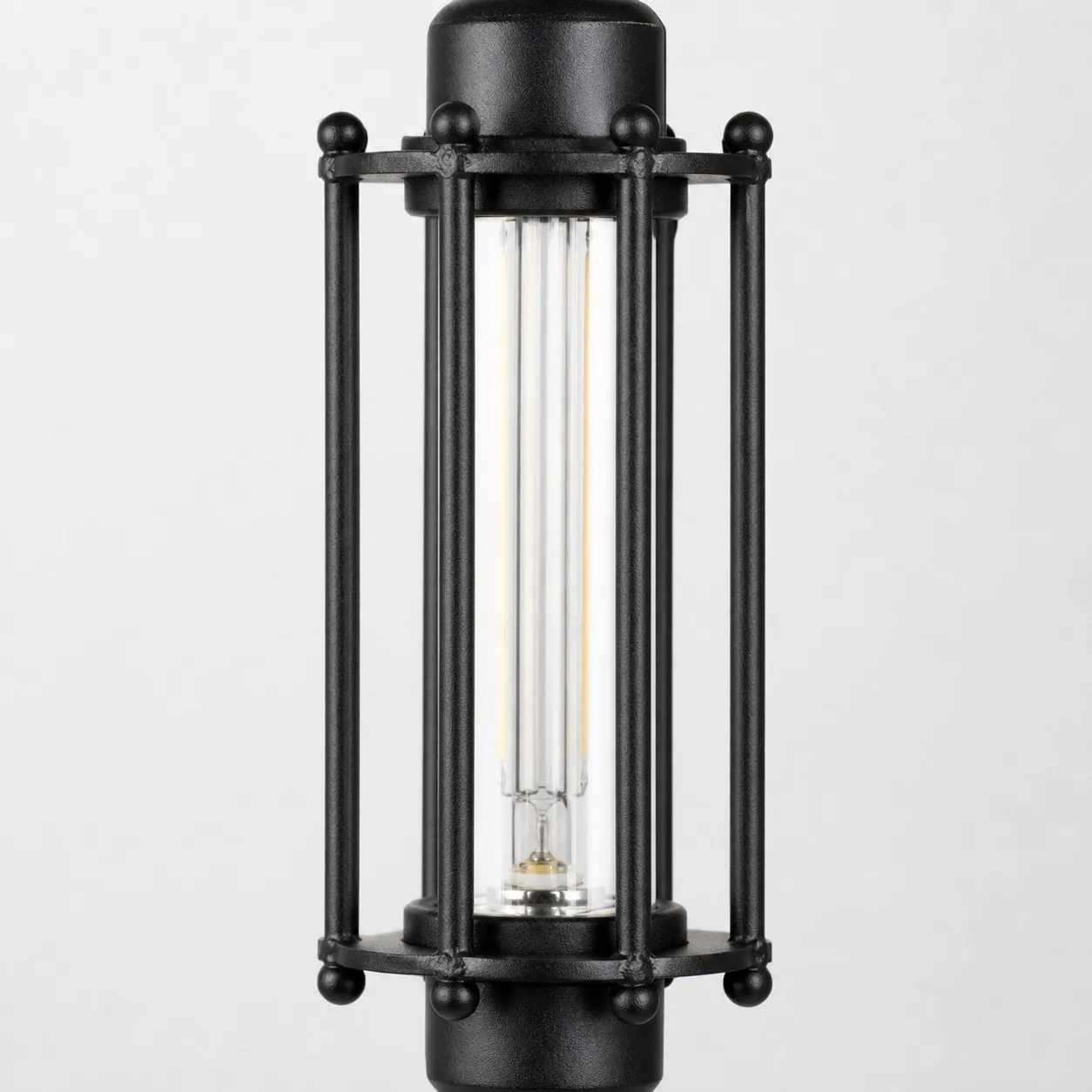 Close view of black tube guard frame and glass shade