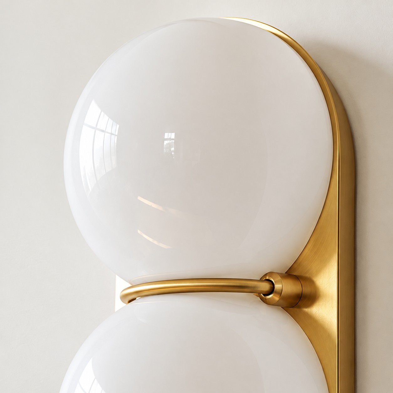 Close view of two white glass globes on a brass backplate