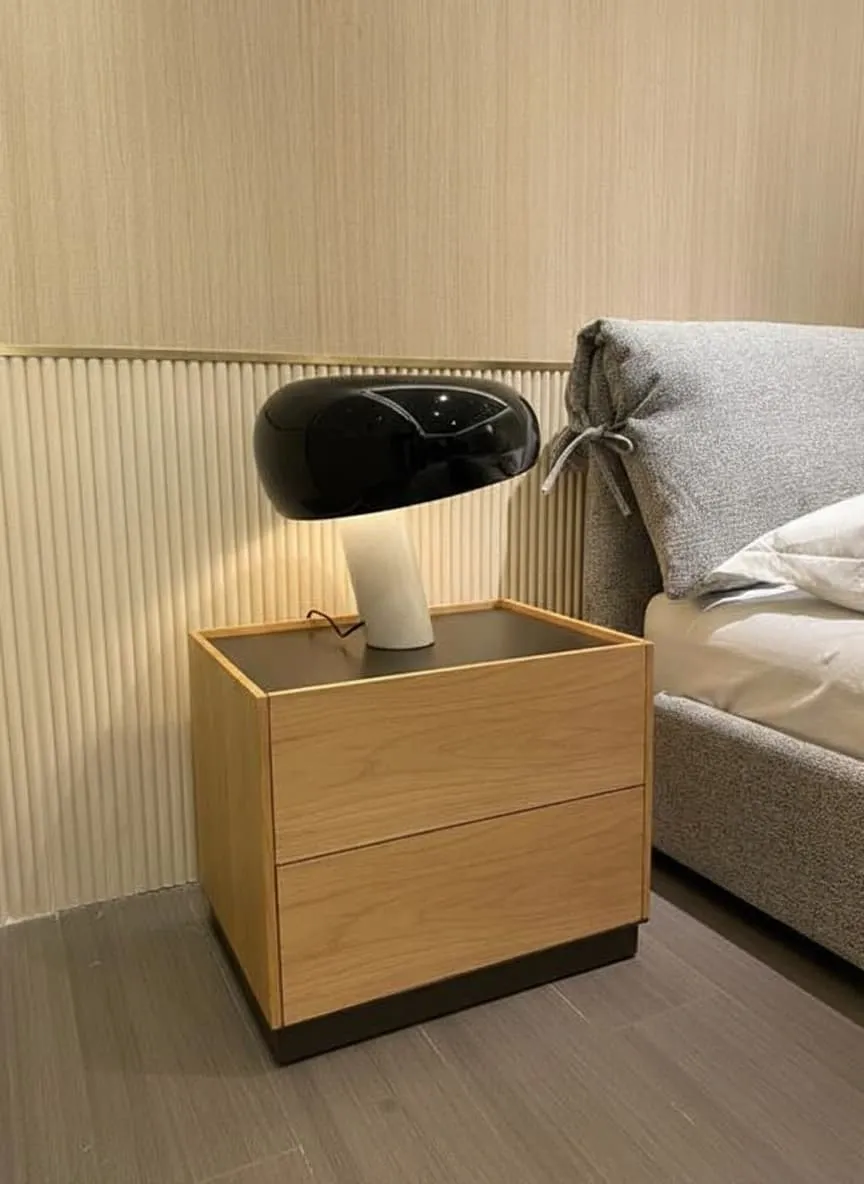 Candeeiro preto aceso numa mesa de cabeceira