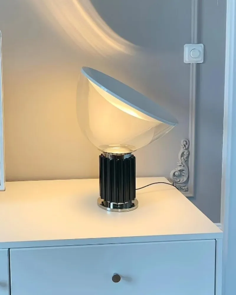 Lampe en bol noir sur une commode blanche