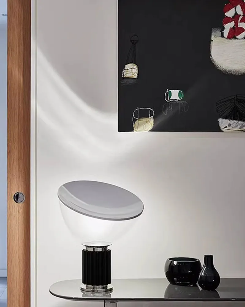 Lampe en bol noir sur une console avec des fleurs