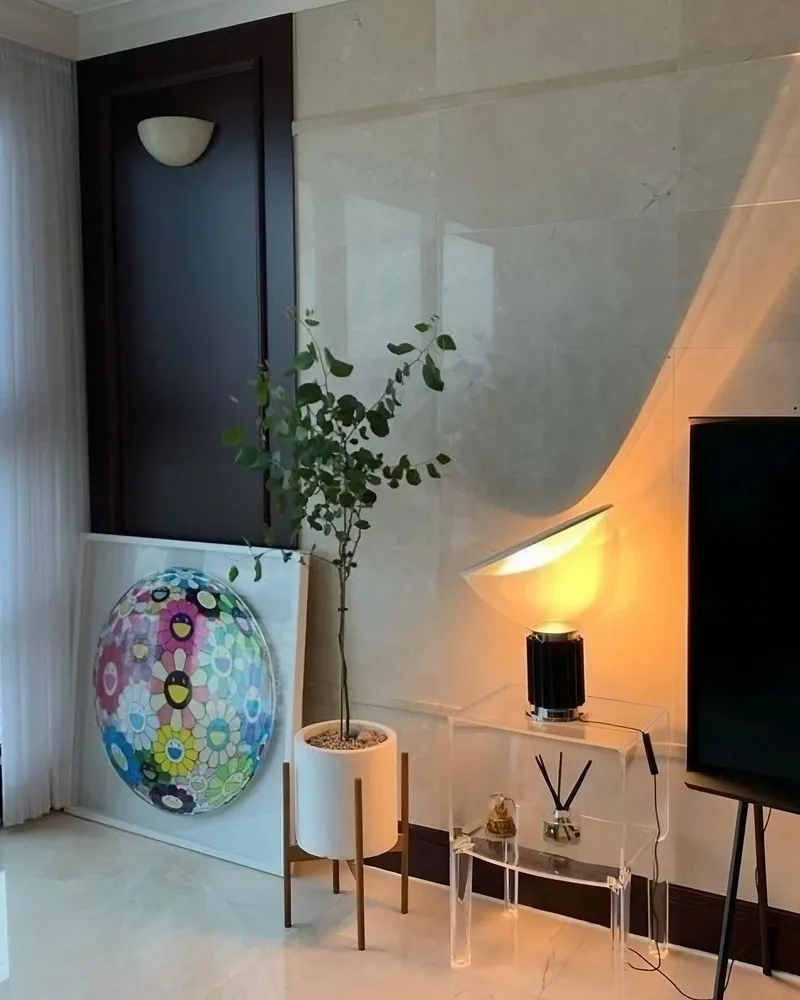 Lampe en bol noir allumée sur une table d’appoint transparente